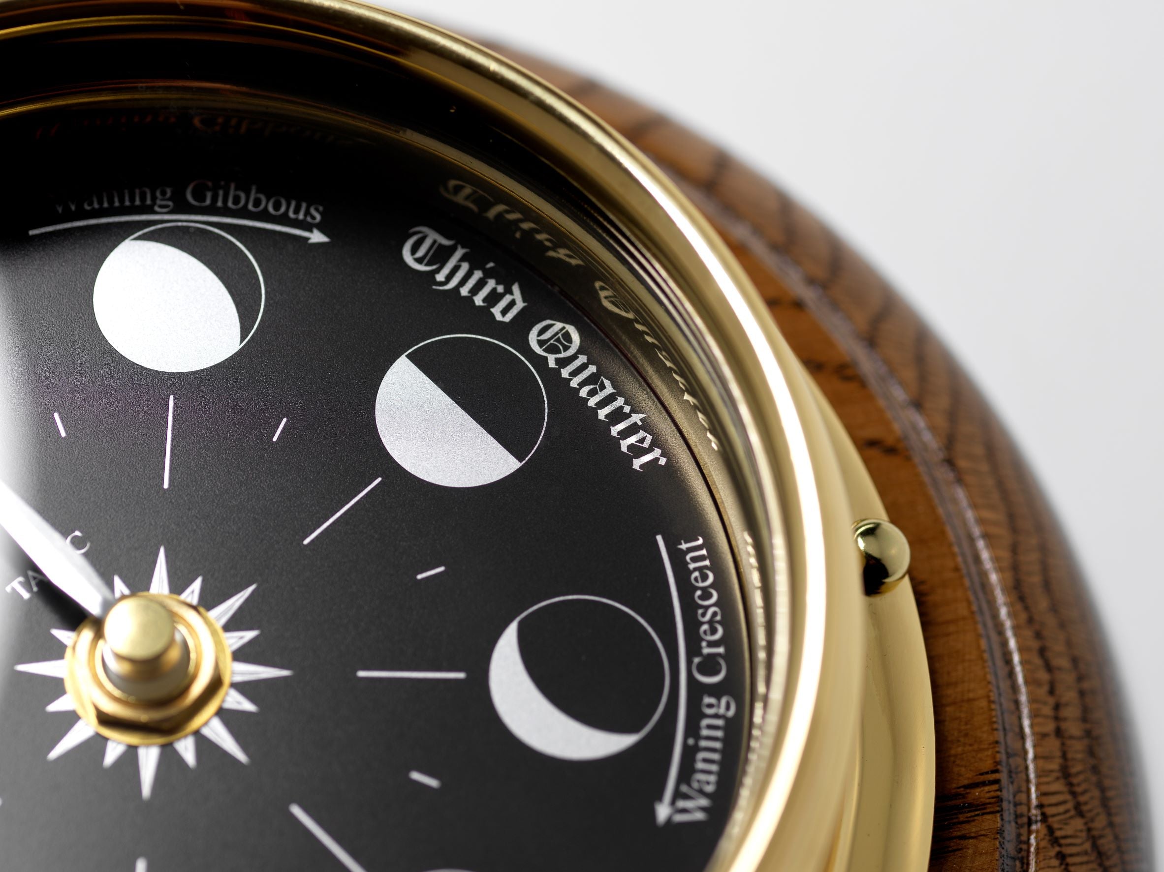 Prestige Brass Moon Phase Clock With a Jet Black Dial Mounted on a Solid English Dark Oak Wall Mount - TABIC CLOCKS
