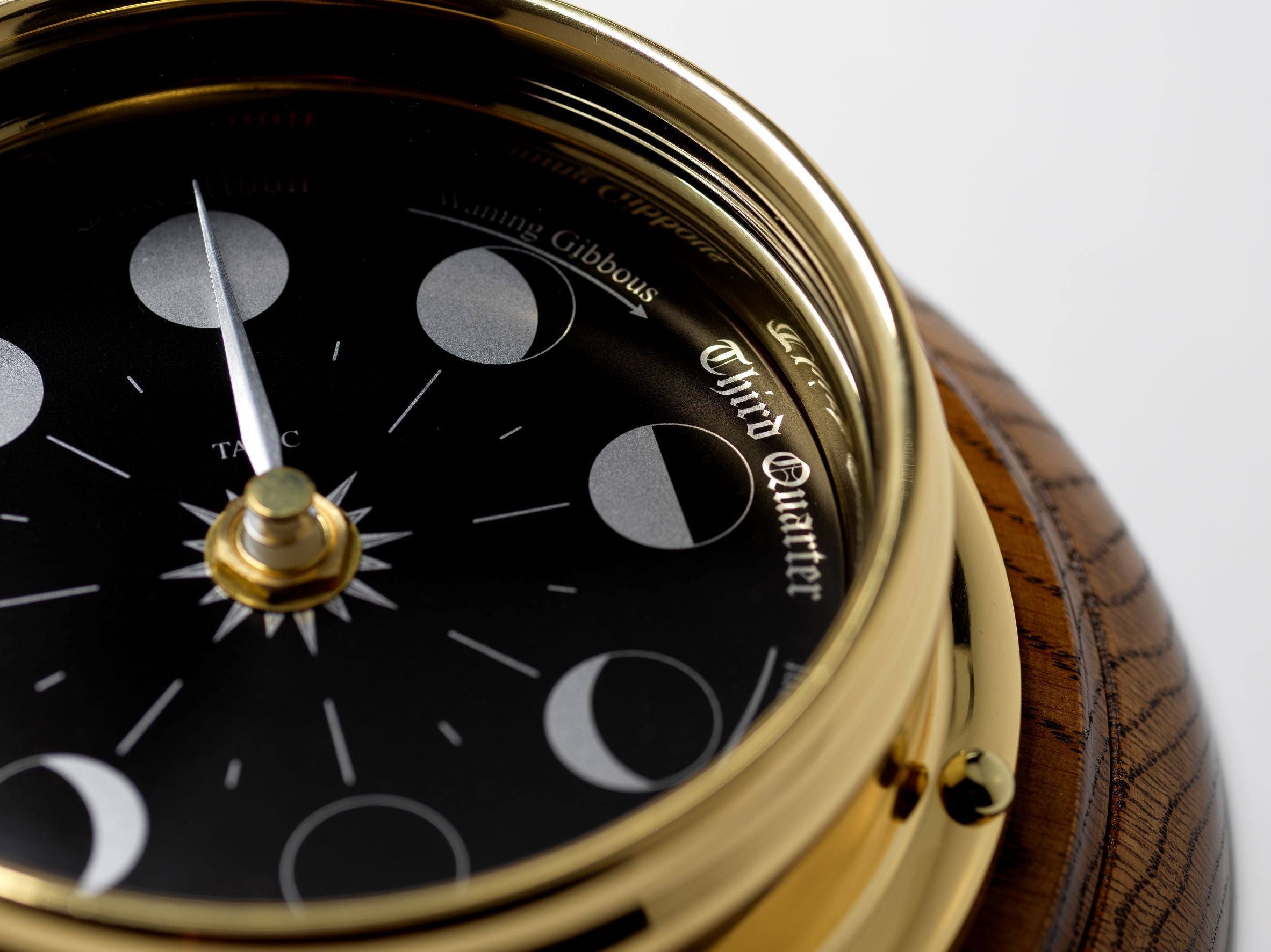 Prestige Brass Moon Phase Clock With a Jet Black Dial Mounted on a Solid English Dark Oak Wall Mount - TABIC CLOCKS