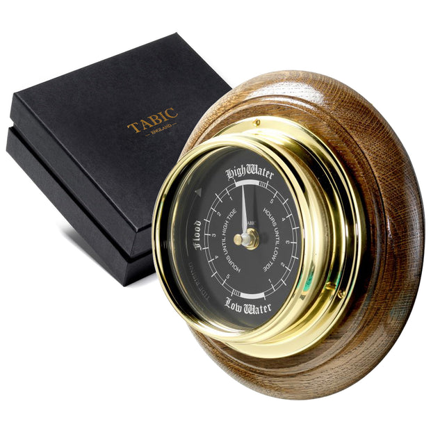 Handmade Prestige Tide Clock in Solid Brass With a Jet Black Dial, mounted on a solid English Dark Oak Wall Mount