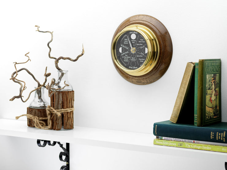 Prestige Brass Moon Gardening clock with A jet Black Mirrored Aluminium Dial, Mounted on a Solid English Dark Oak Wall Mount